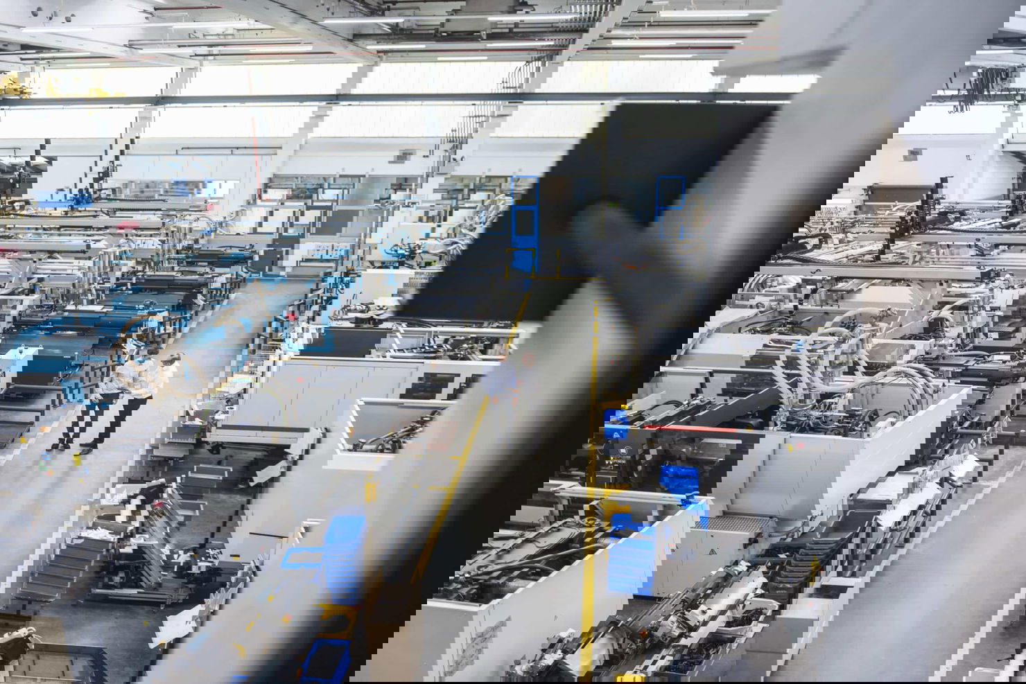 Manufacturing facility with real-time OEE monitoring - operators reviewing production line performance and equipment effectiveness