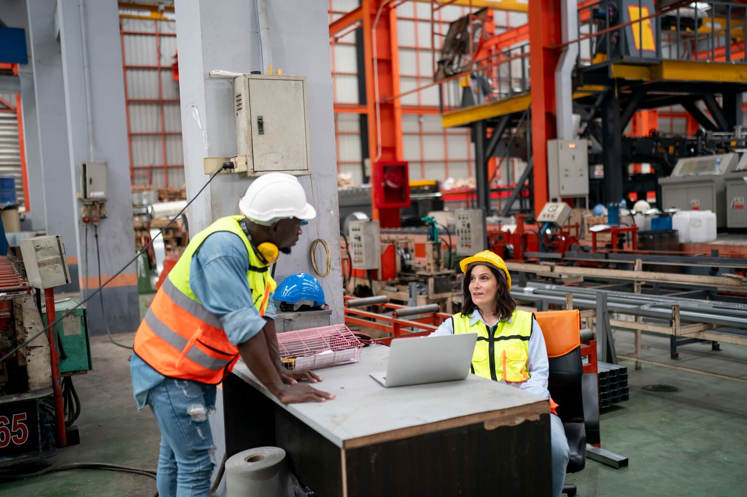 Industry engineer worker at factory Opérateurs industriels consultant des données OEE en temps réel sur ordinateur portable dans un atelier de production moderne